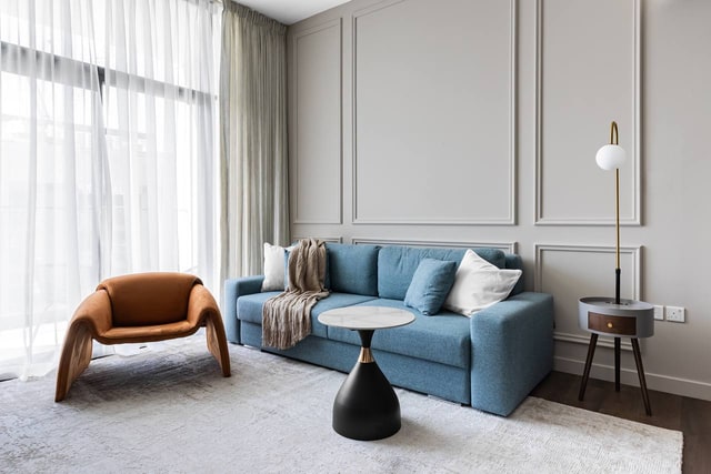 Blue sofa and caramel armchair in a bright Dubai apartment